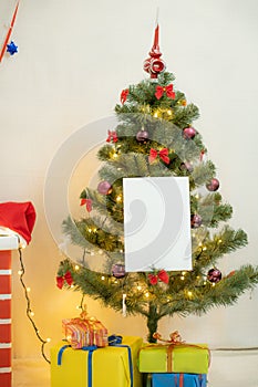 White blank sheet of paper against the background of the Christmas tree and the fireplace
