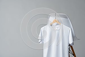 White blank t-shirt hanging on chair in empty room copy space