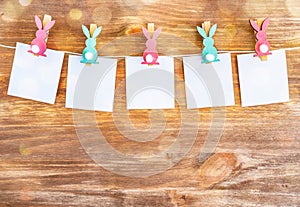 White blanks with rabbits pins on wooden background. Easter decoration