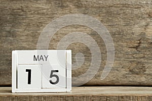 White block calendar present date 15 and month May on wood background