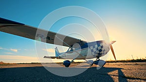 White and blue airplane on a runway, close up.