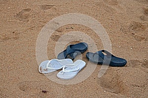 WHITE AND BLUE FLIPFLOPS ON THE BEACH