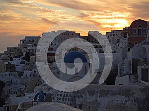 White and blue Greek Island Style architecture against golden evening sky at Oia village, Santorini Island