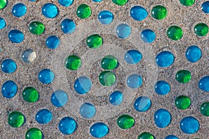 White, blue and green glass beads on sand