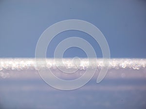 White, blue and grey bokeh effect and purposely blurred view of sea or ocean landscape. Blurry and shiny water and sky background