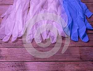 White and blue medical gloves lie on a wooden table