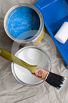 White and blue paint in cans and brush