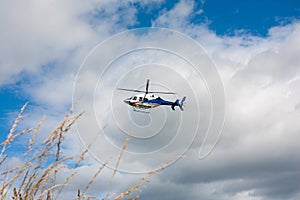 White blue red painted helicopter in flight