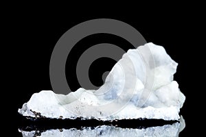 White blue stalactite or sinter of calcium oxide, raw stone in front of black background, geology and sintering