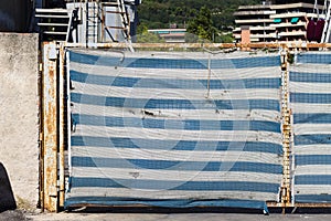 A white and blue striped panel on a construction site gate Italy, Europe