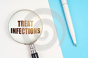 On a white - blue surface are a pen and a magnifying glass with the inscription - Treat Infections