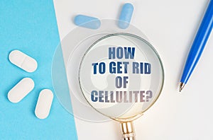 On a white and blue surface are pills, a pen and a magnifying glass with the inscription - How to Get Rid Of Cellulite