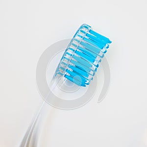 White blue toothbrush on a white background, close-up medical abstract background