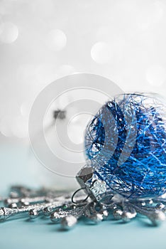 White and blue xmas ornaments on glitter bokeh background. Merry christmas card.