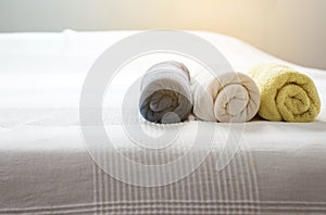 White,Blue,Yellow towel on bed,Stack of plush hotel towels