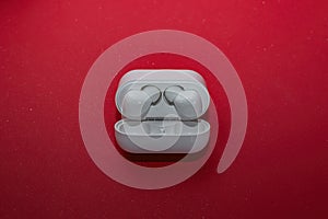 White bluetooth wireless headphones on a red background