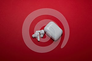 White bluetooth wireless headphones on a red background