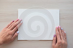 White board with hands for copy space. School office supplies on wooden background. Back to school concept. Top view ready for