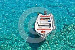 White boat at crystal clear blue water of Marmara beach, near Aradena gorge, island of Crete