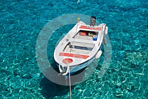 White boat at crystal clear blue water of Marmara beach, near Aradena gorge, island of Crete photo