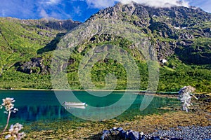 White boat in the lake with view to mountains in the Norway at summer