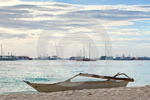 White boat on sand beach tropical sea on sunset