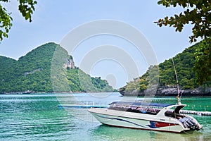 White boat on the shore against the backdrop of the pier and mountains