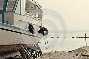 White boat on the shore with hanging tires Ari Atoll, Maldives