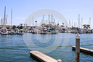 White boats and yachts at the docks in the harbor with deep blue ocean water and blue sky at Burton Chace Park