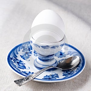 white boiled egg on plate with metal tea-spoon