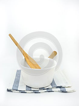 White boiling pan and wooden spatula on a fabric