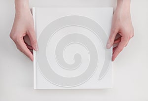 White book mockup. Square empty book. Album with clean pages in hands of woman. Clean book cover mockup