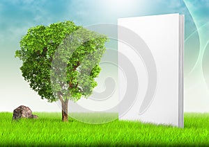 White book and tree in field of grass under blue