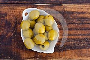 White bowl with boned green olives photo