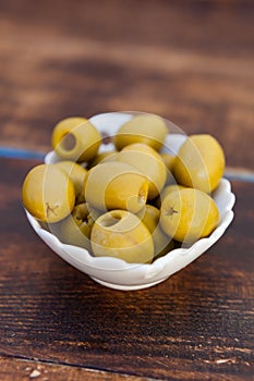 White bowl with boned green olives photo