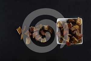 White bowl of candied rheum isolated on black background flat lay