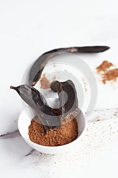 white bowl with carob powder and been