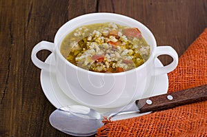 White bowl of chicken and wild rice soup with vegetables