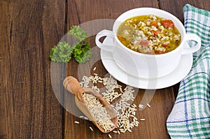 White bowl of chicken and wild rice soup with vegetables