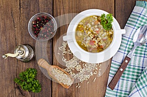 White bowl of chicken and wild rice soup with vegetables