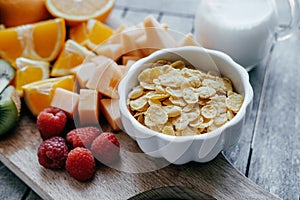 White bowl with corn Flakes and milk and Fresh sliced fruit: ra