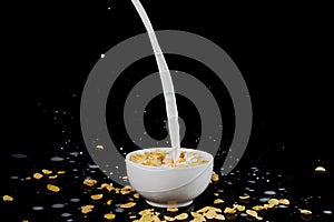 Bowl with cornflakes with milk stream