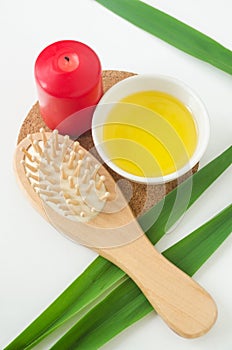 White bowl with cosmetic (massage, cleansing) aroma oil and wooden hairbrush. Natural skin and hair care, homemade spa