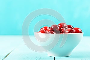 White Bowl Of Fresh Red Cherries On Turquoise