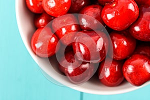 White Bowl Of Fresh Red Cherries On Turquoise