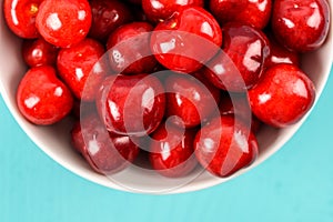 White Bowl Of Fresh Red Cherries On Turquoise