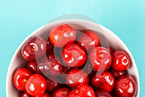 White Bowl Of Fresh Red Cherries On Turquoise