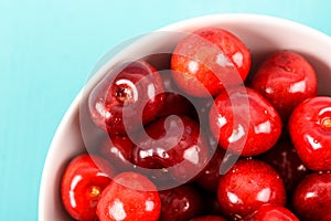 White Bowl Of Fresh Red Cherries On Turquoise