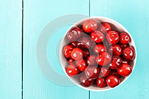 White Bowl Of Fresh Red Cherries On Turquoise