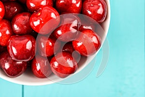 White Bowl Of Fresh Red Cherries On Turquoise